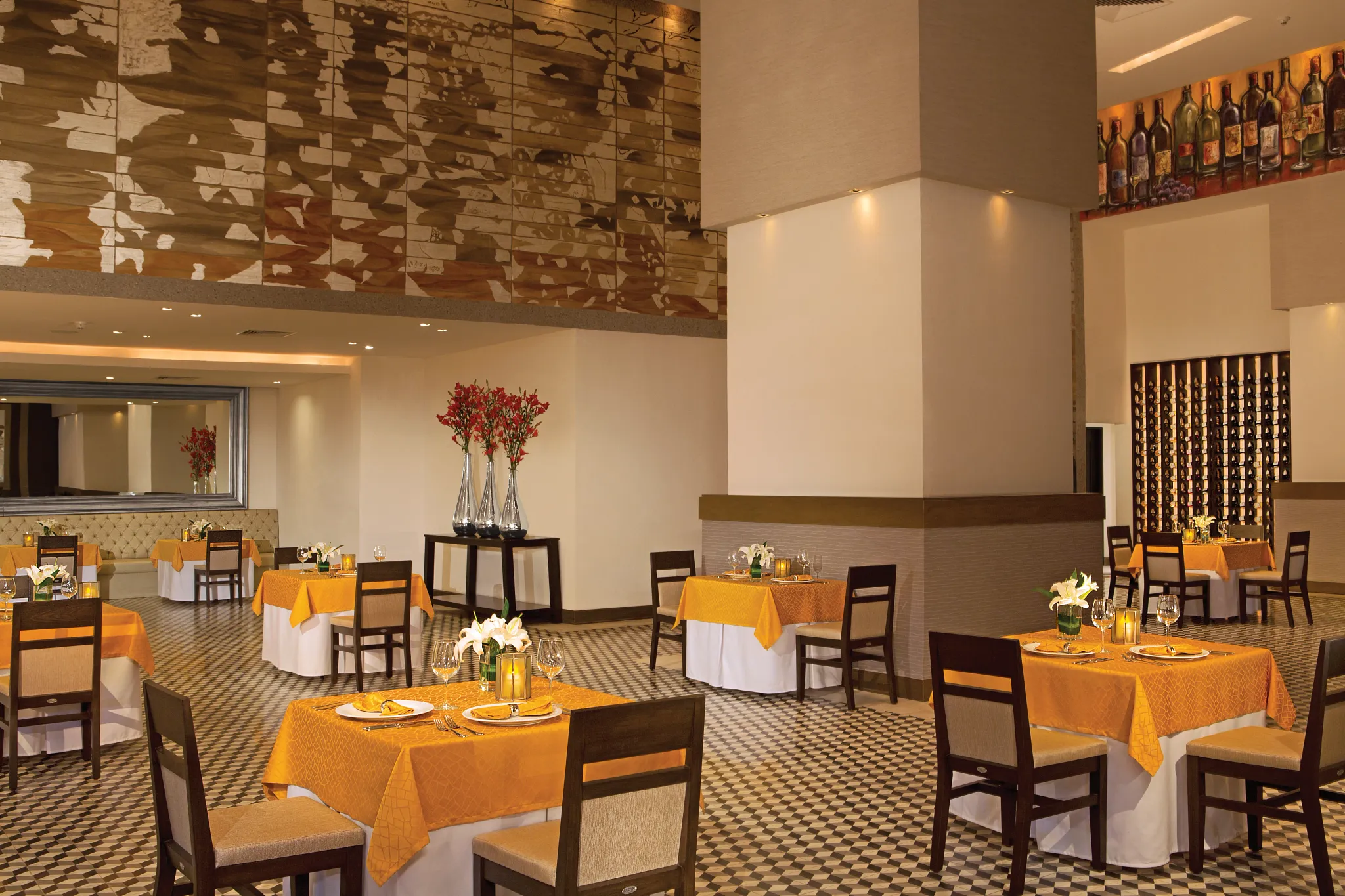 Capers Italian restaurant at Dreams Vallarta Bay Resort & Spa featuring elegant dining tables, warm lighting, and an extensive wine cellar display.