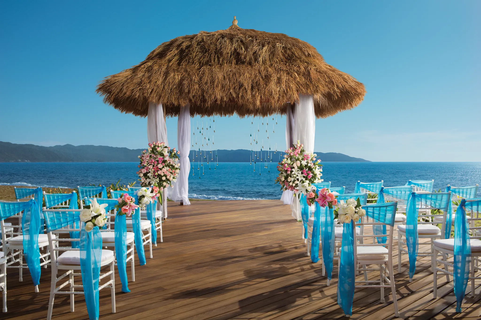 Beach gazebo ceremony setup with turquoise décor at Dreams Vallarta Bay Resort & Spa