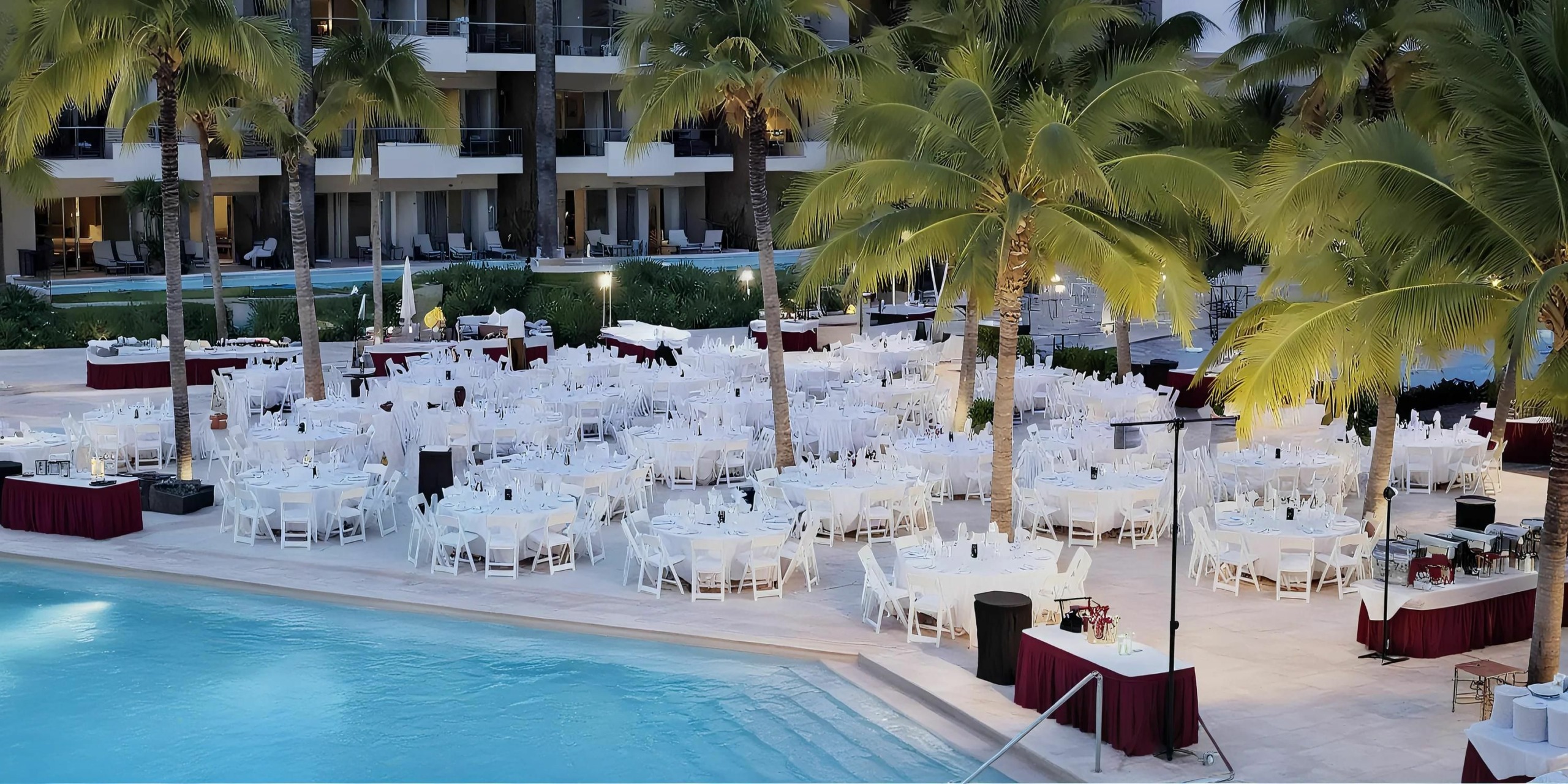 Pool terrace wedding reception setup with palm trees at Dreams Vallarta Bay Resort & Spa