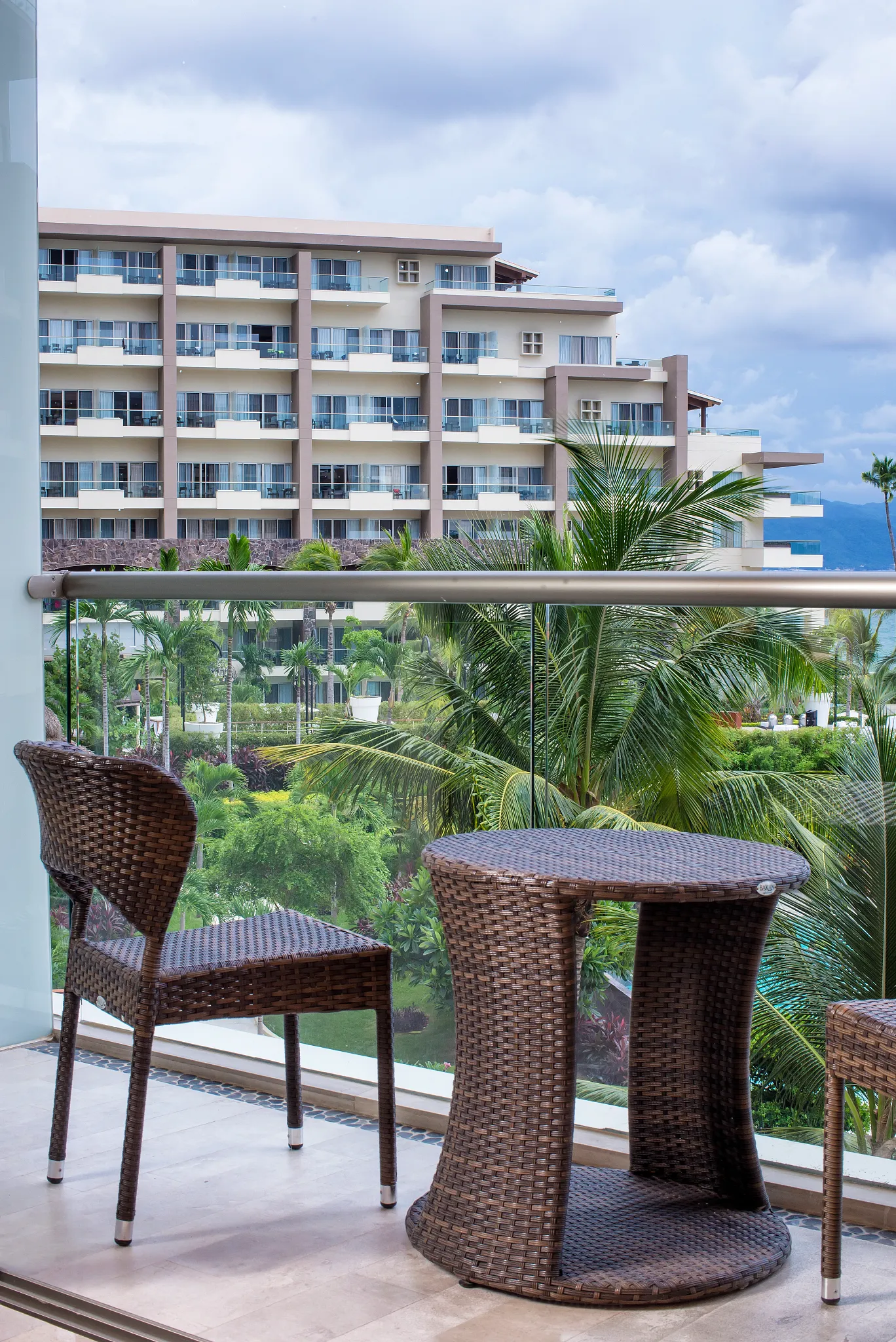 Private furnished balcony with garden views at the Junior Suite Garden View King at Dreams Vallarta Bay Resort & Spa.