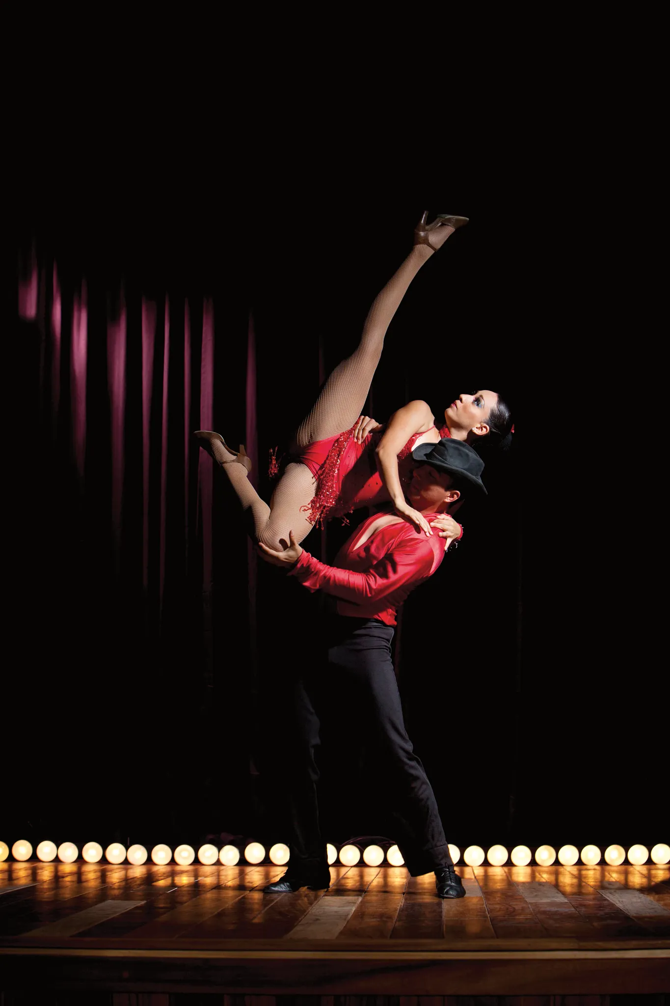 Professional dancers performing a dramatic stage lift during a live entertainment show at Dreams Vallarta Bay Resort & Spa.