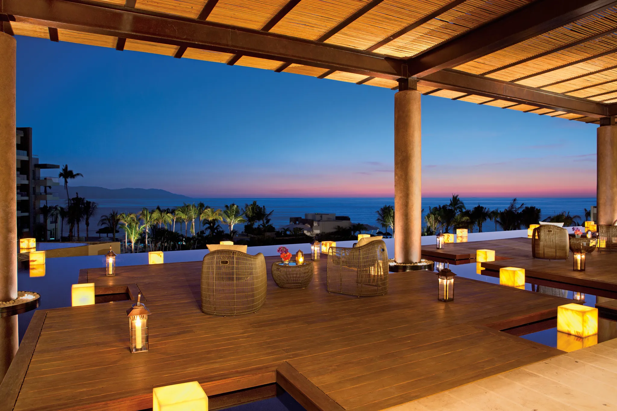 Romantic oceanview terrace at night with lantern lighting at Dreams Vallarta Bay Resort & Spa.