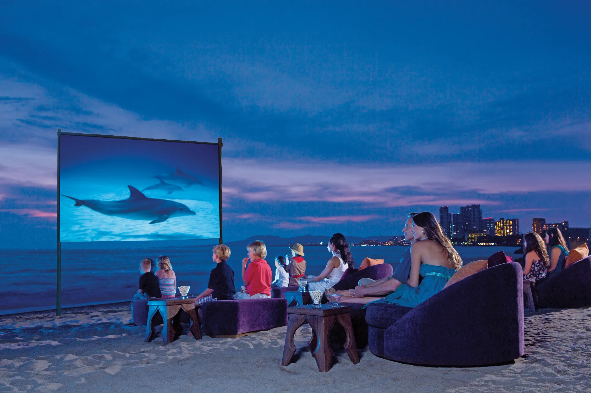 Families watching a movie on the beach at night at Dreams Vallarta Bay Resort & Spa in Puerto Vallarta.